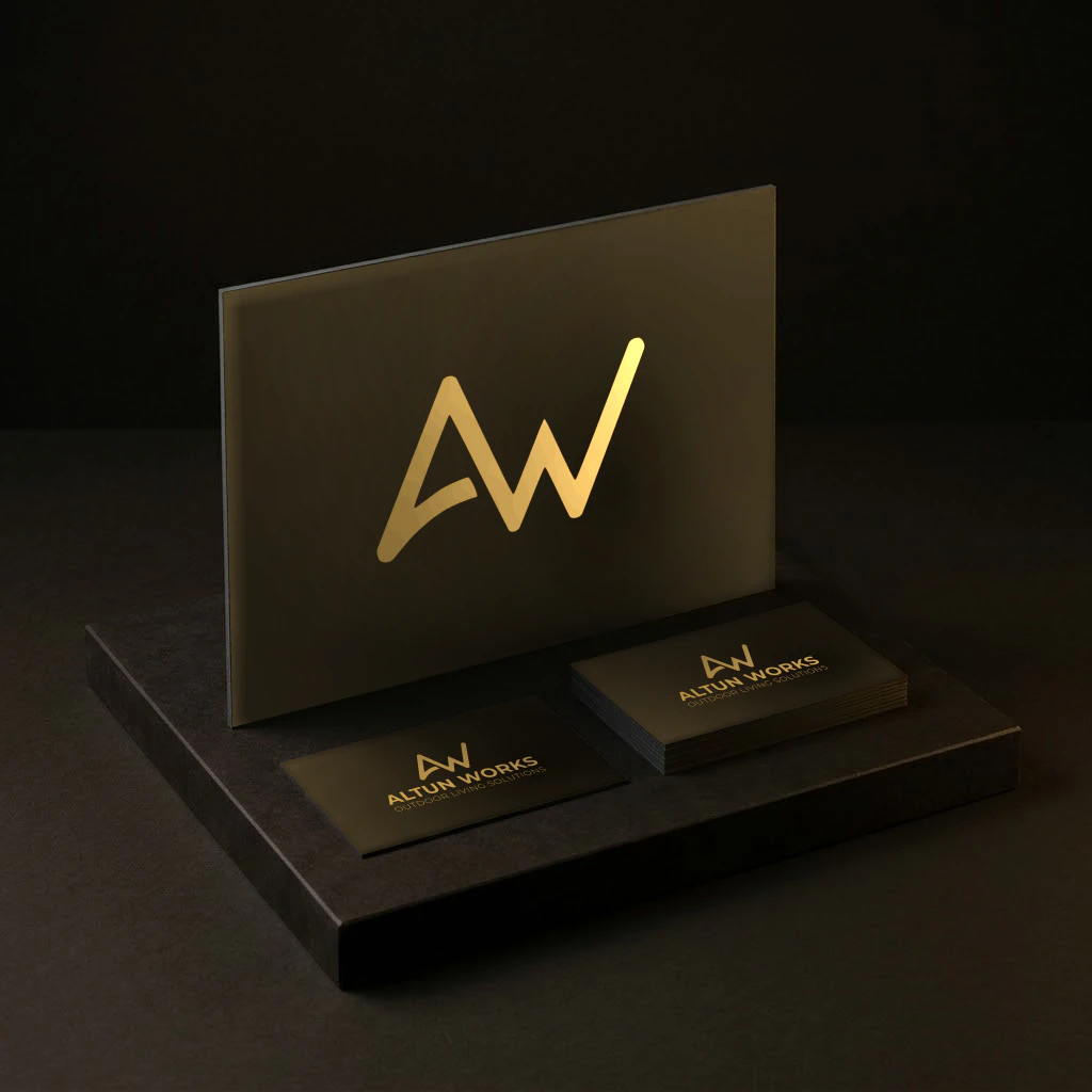 Altun Works' brandmark on a standing board, with a stack of its business cards and one loose card in front, as delivered.